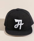 Limited first edition 'A' cap, a classic snapback by Uppr Lowr. The cap features a hand-drawn custom letterform 'A' by Travis Price, exclusive for Uppr Lowr. Crafted from a wool blend, it showcases custom raised embroidery and a deep fit. This collectable cap is a must-have for streetwear enthusiasts.