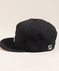 Limited first edition 'A' cap, a classic snapback by Uppr Lowr. The cap features a hand-drawn custom letterform 'A' by Travis Price, exclusive for Uppr Lowr. Crafted from a wool blend, it showcases custom raised embroidery and a deep fit. This collectable cap is a must-have for streetwear enthusiasts.